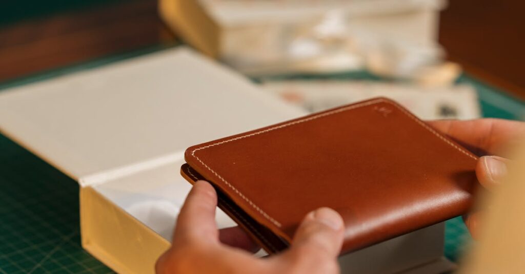Close-up of a person crafting a leather wallet in a well-organized workspace.